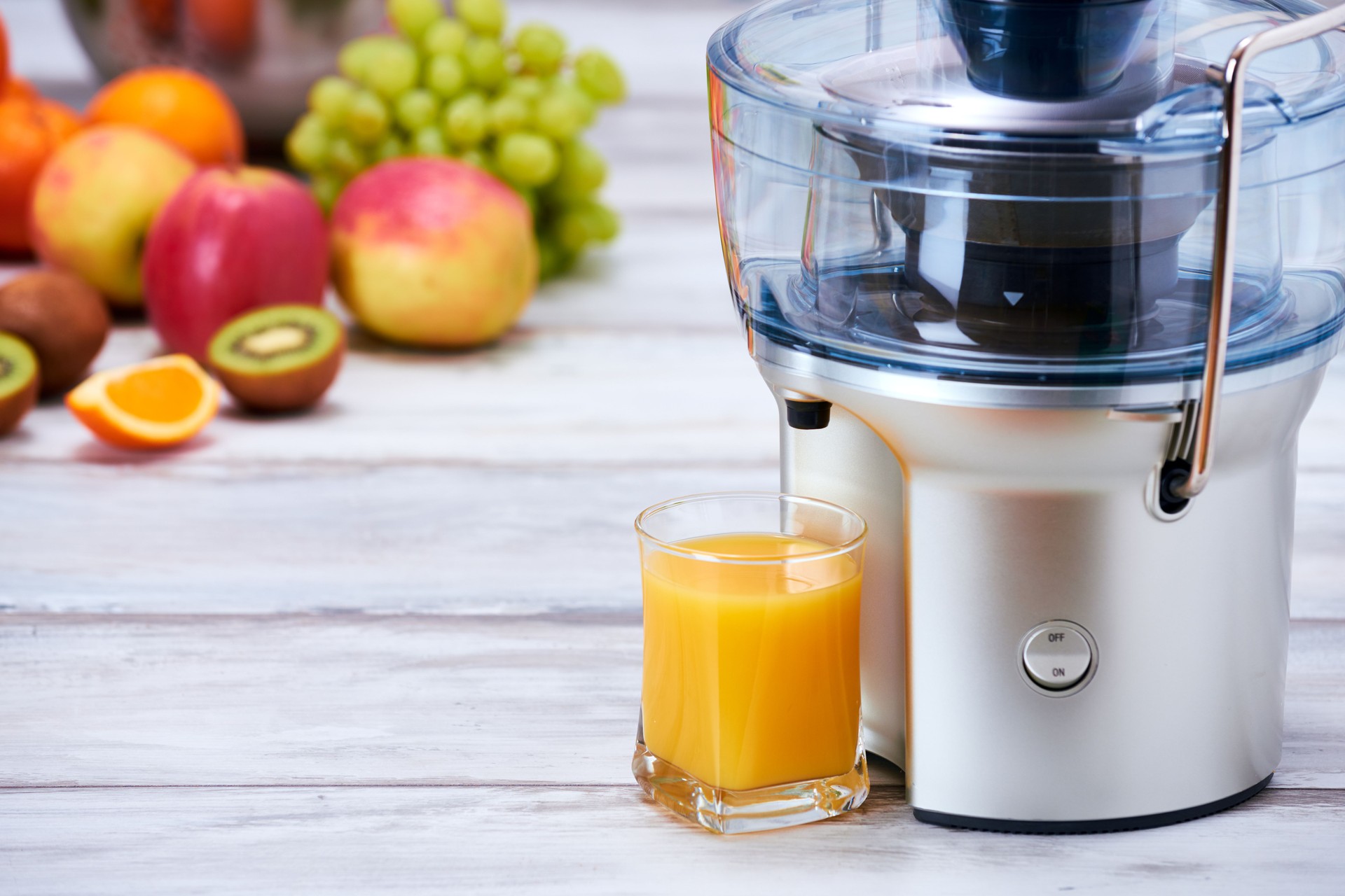 Juicer, fruit and glass of freshly made juice, detox concept